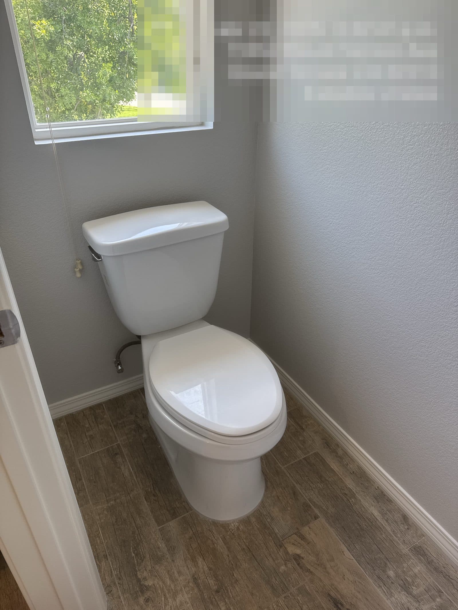 Finished bathroom rebuild in Grand Terrace CA with dual sink vanity and wood-look flooring — photo 1
