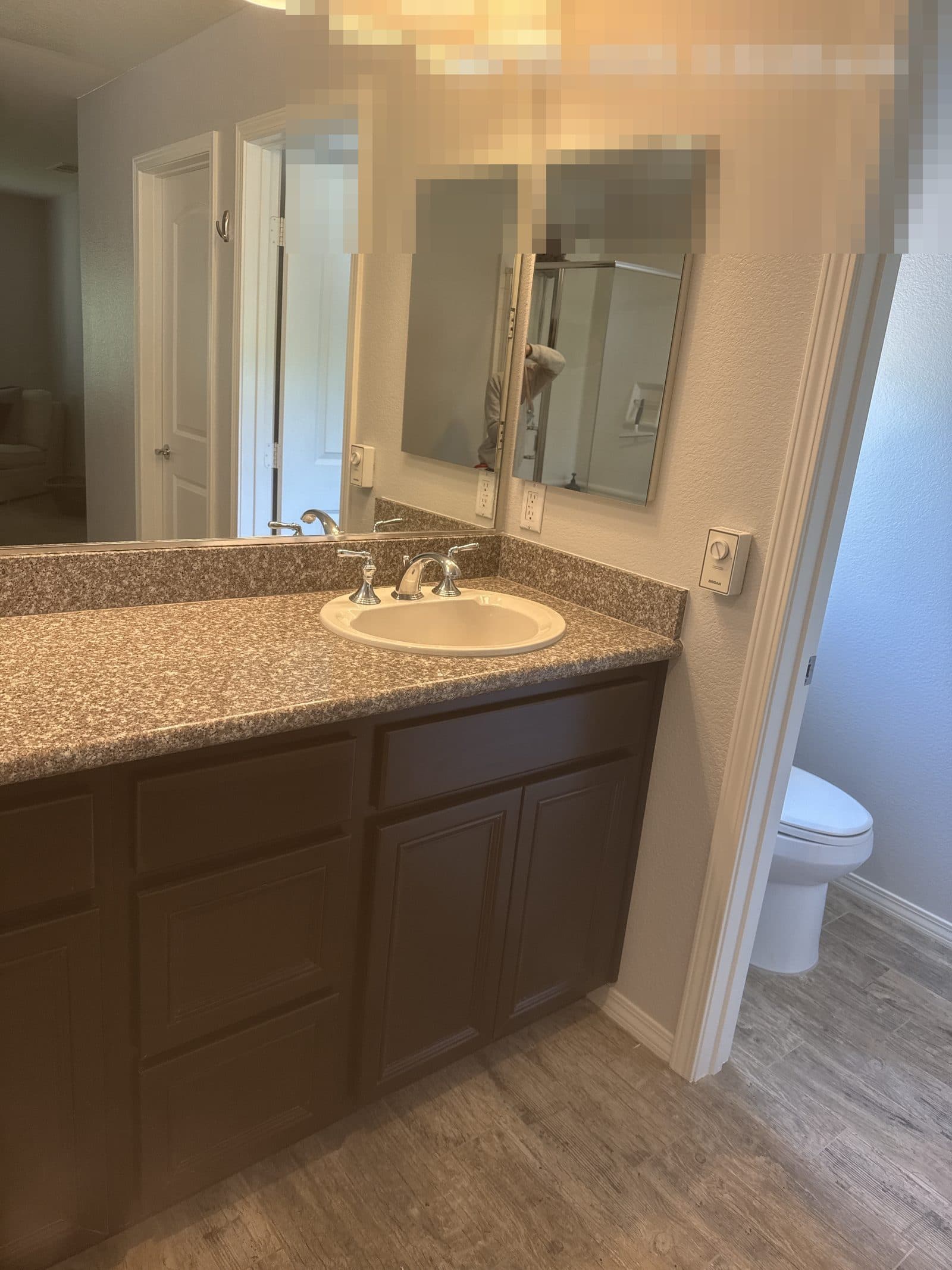 Finished bathroom rebuild in Grand Terrace CA with dual sink vanity and wood-look flooring — photo 3