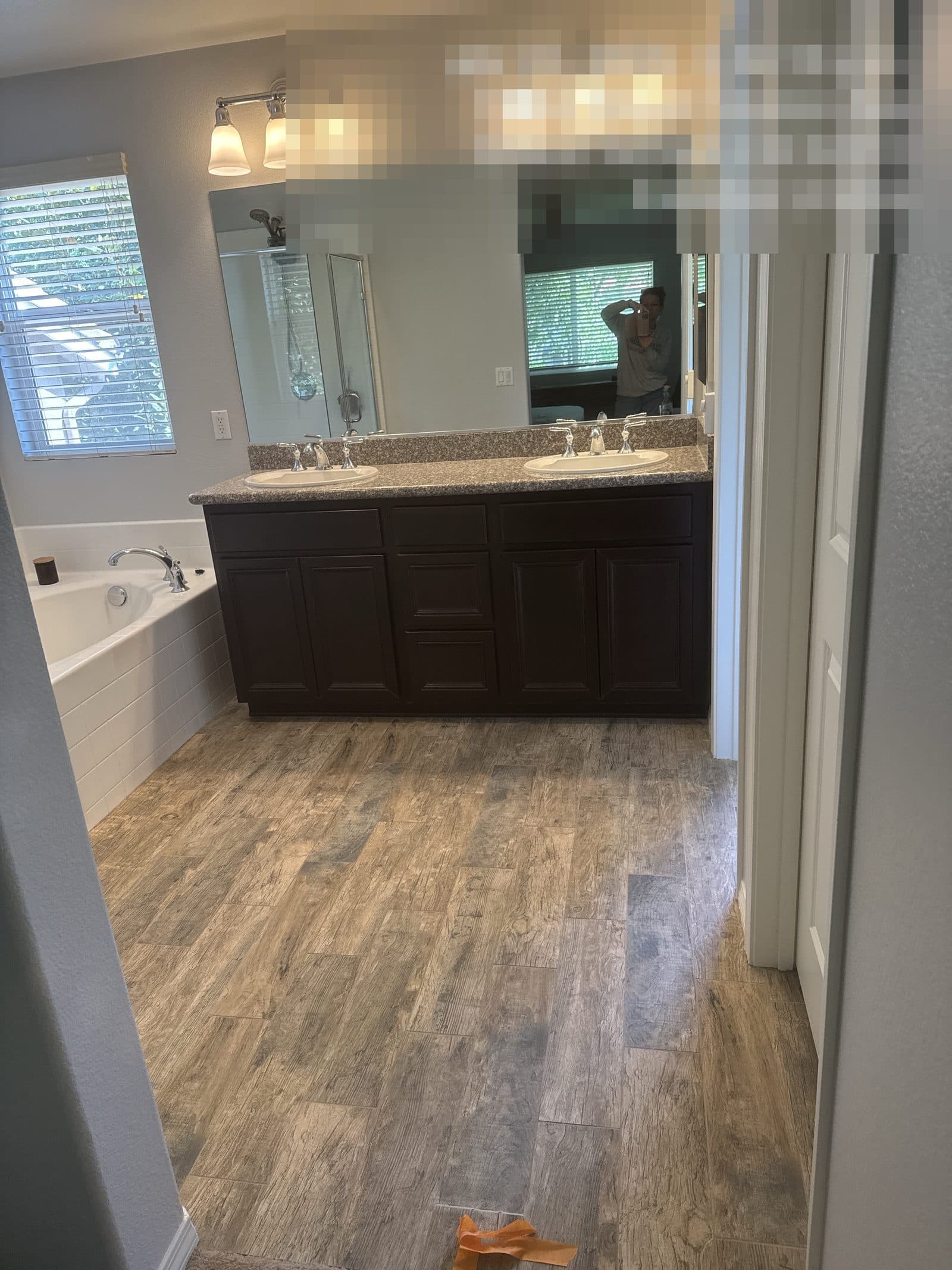 Finished bathroom rebuild in Grand Terrace CA with dual sink vanity and wood-look flooring — photo 4