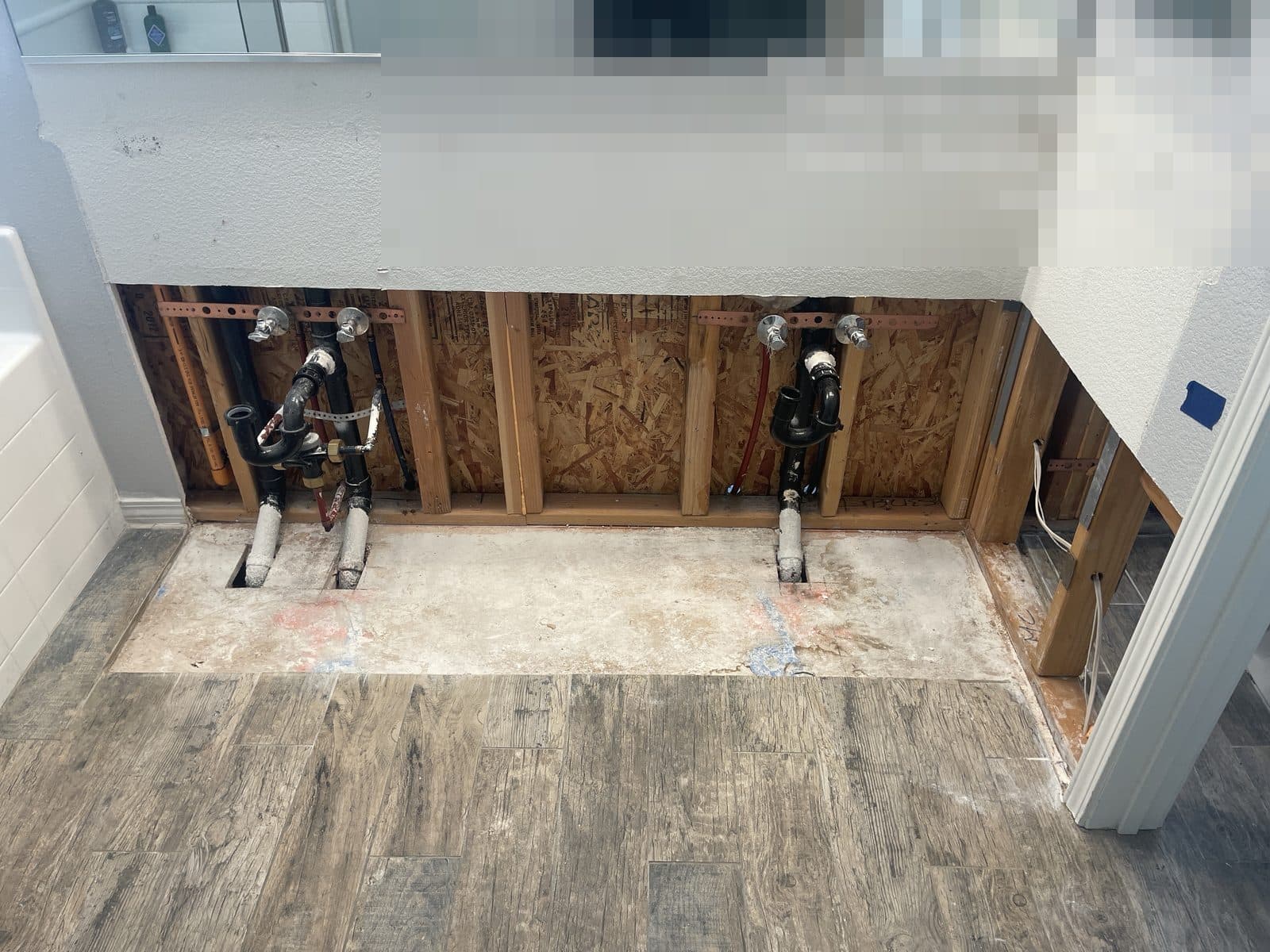 Bathroom wall opened to studs after plumbing failure in Grand Terrace CA, before rebuild — photo 1